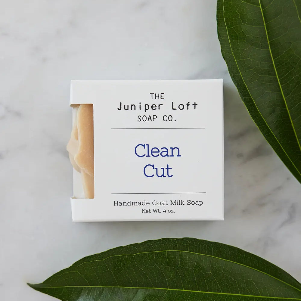 Two large green leaves around a bar of Clean Cut soap from Juniper Loft Soap Company