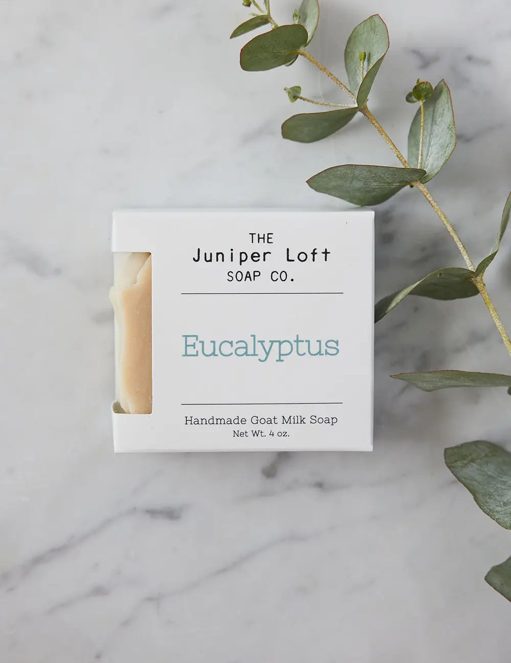 Bar of Eucalyptus soap from Juniper Loft Soap Company with a long stem of eucalyptus