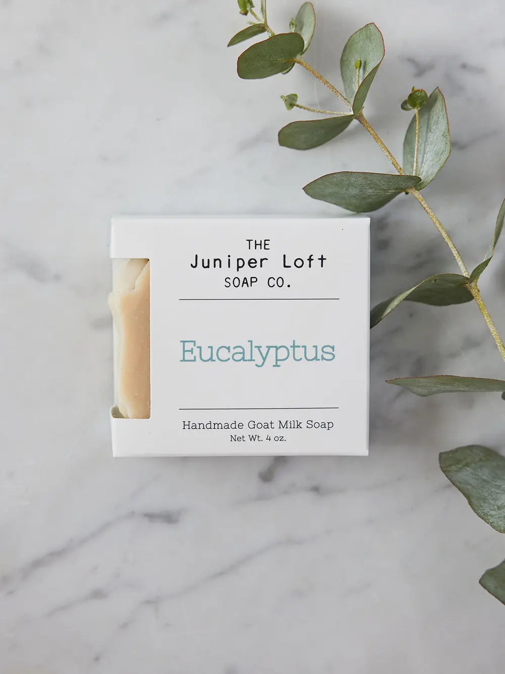 Bar of Eucalyptus soap from Juniper Loft Soap Company with a long stem of eucalyptus