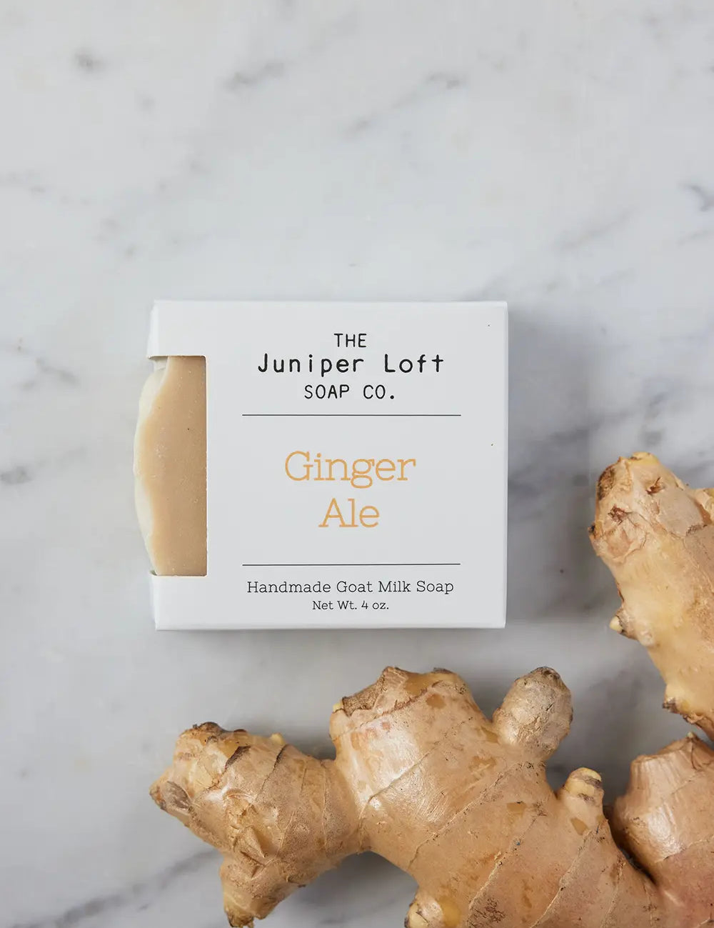 Bar of Ginger Ale soap from Juniper Loft Soap Company beside a large piece of ginger root