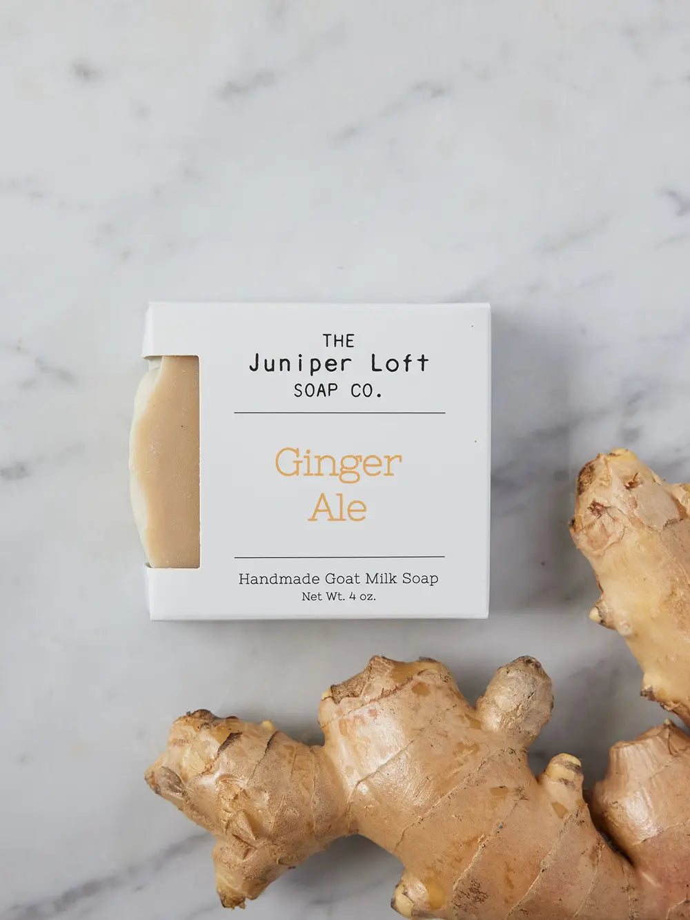 Bar of Ginger Ale soap from Juniper Loft Soap Company beside a large piece of ginger root