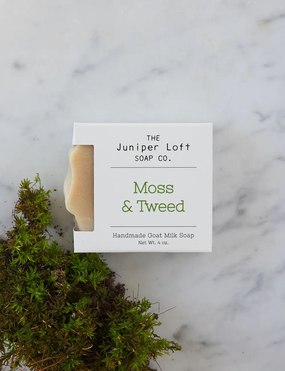 Bar of Moss and Tweed soap from Juniper Loft Soap Company beside some moss