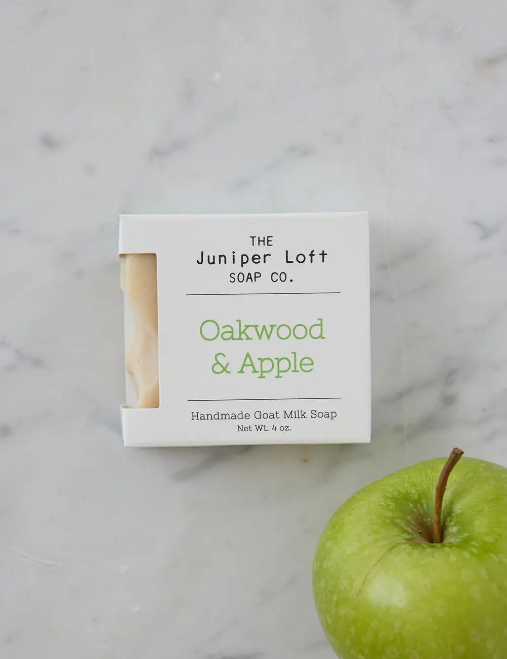 Bar of Oakwood and Apple soap from Juniper Loft Soap Company beside a green apple