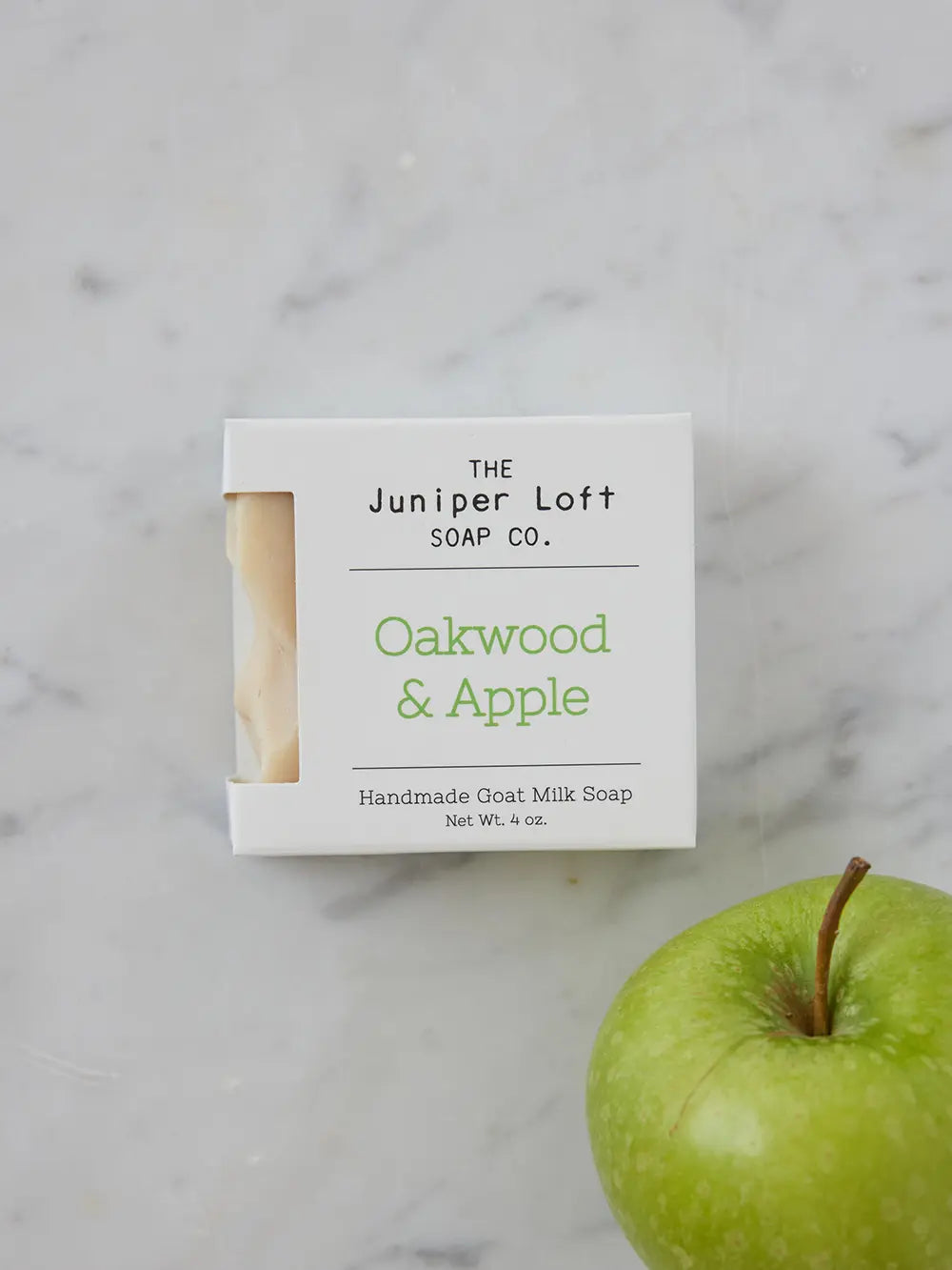 Bar of Oakwood and Apple soap from Juniper Loft Soap Company beside a green apple