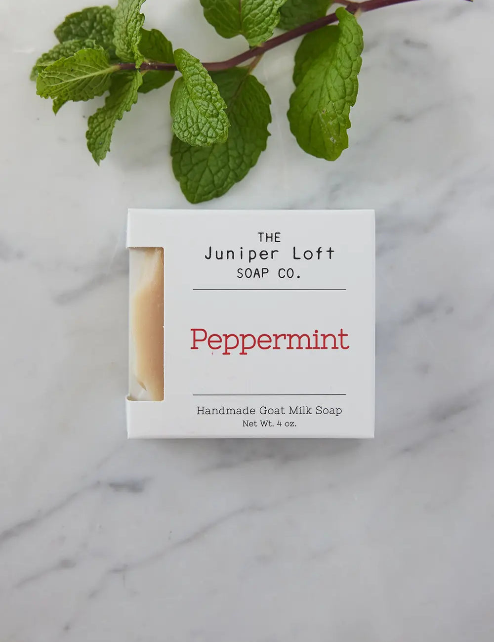 Bar of Peppermint soap from Juniper Loft Soap Company with a spring of peppermint above it