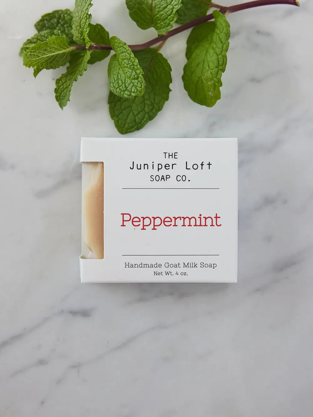 Bar of Peppermint soap from Juniper Loft Soap Company with a spring of peppermint above it