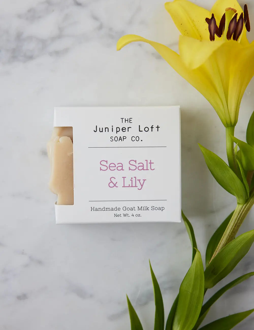 Bar of Sea Salt and Lily soap from Juniper Loft Soap Company beside a large yellow Asiatic Lily