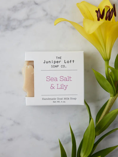 Bar of Sea Salt and Lily soap from Juniper Loft Soap Company beside a large yellow Asiatic Lily
