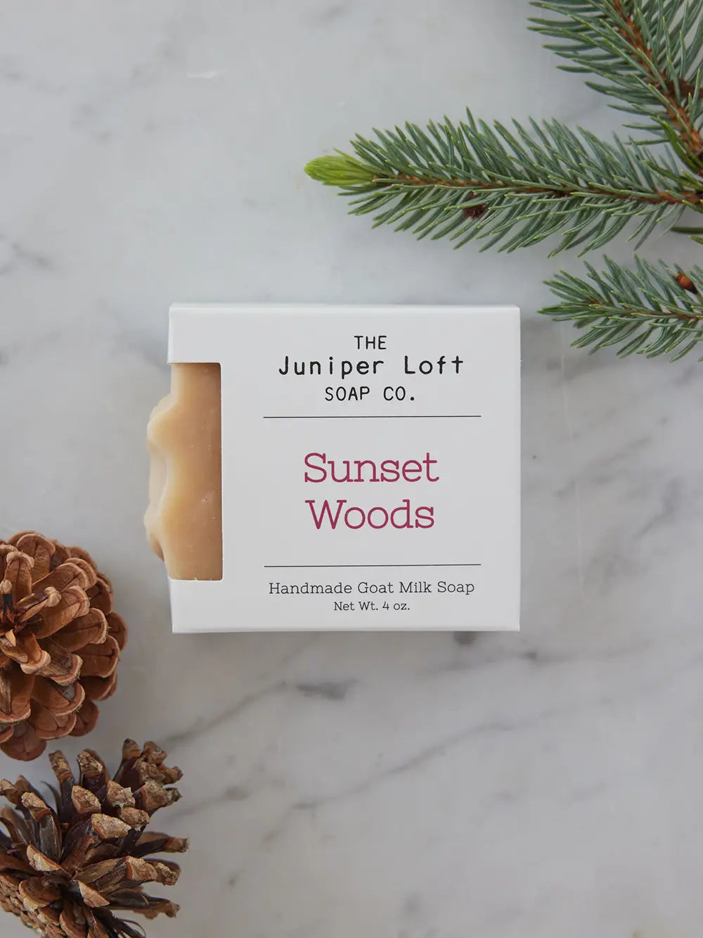 Bar of Sunset Woods soap from Juniper Loft Soap Company surrounded by pine needles and cones