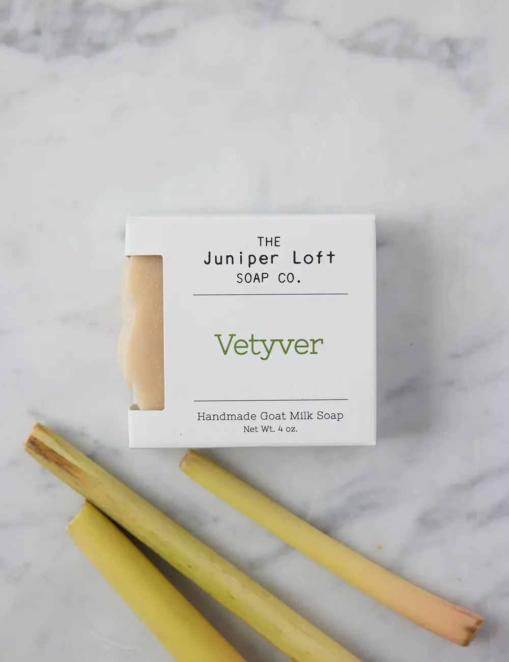 Bar of Vetyver soap from Juniper Loft Soap Company next to three slips of vetyver