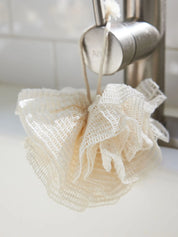 Ramie mesh pouf from Juniper Loft Soap Company hangs from a shower handle