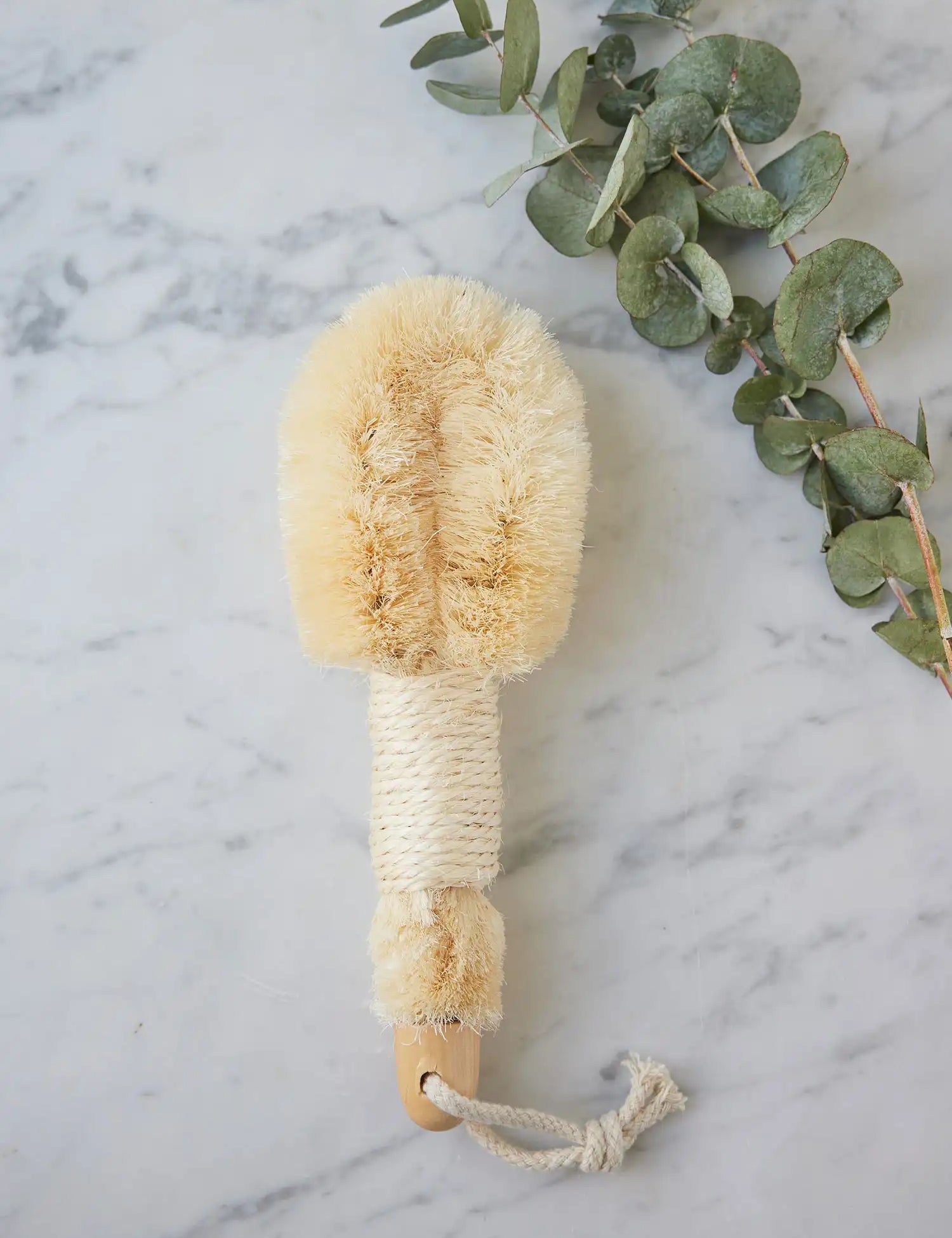 Skin-Smoothing Body Brush from Juniper Loft Soap Company on a gray marble countertop