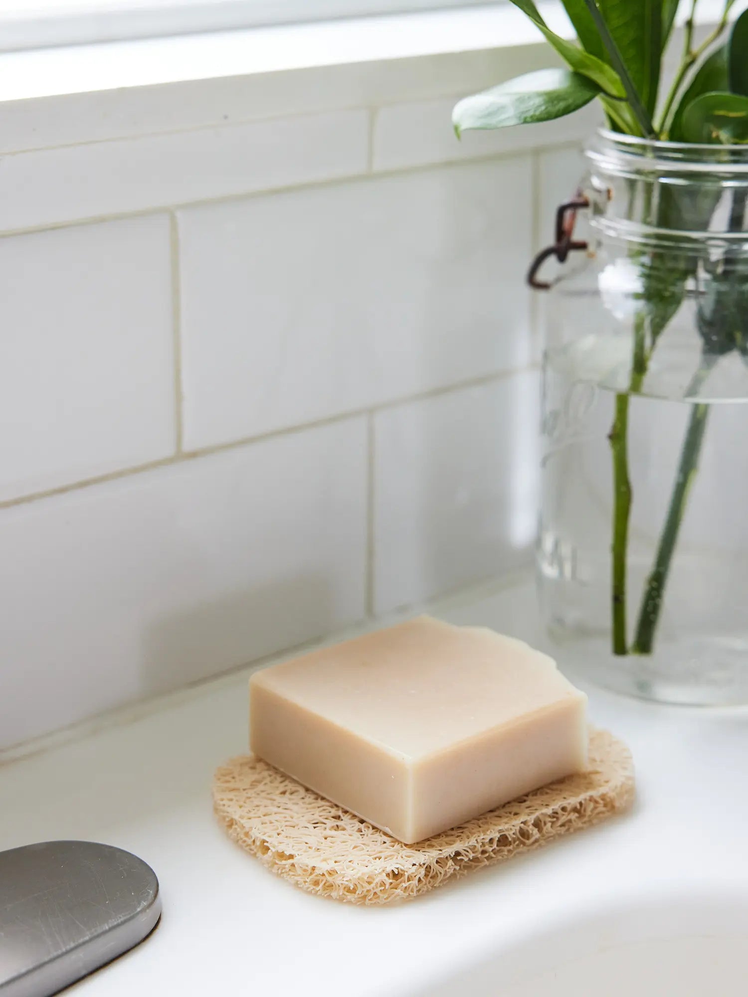 Closeup of a bar of Juniper Loft Soap Company soap on a soap saver