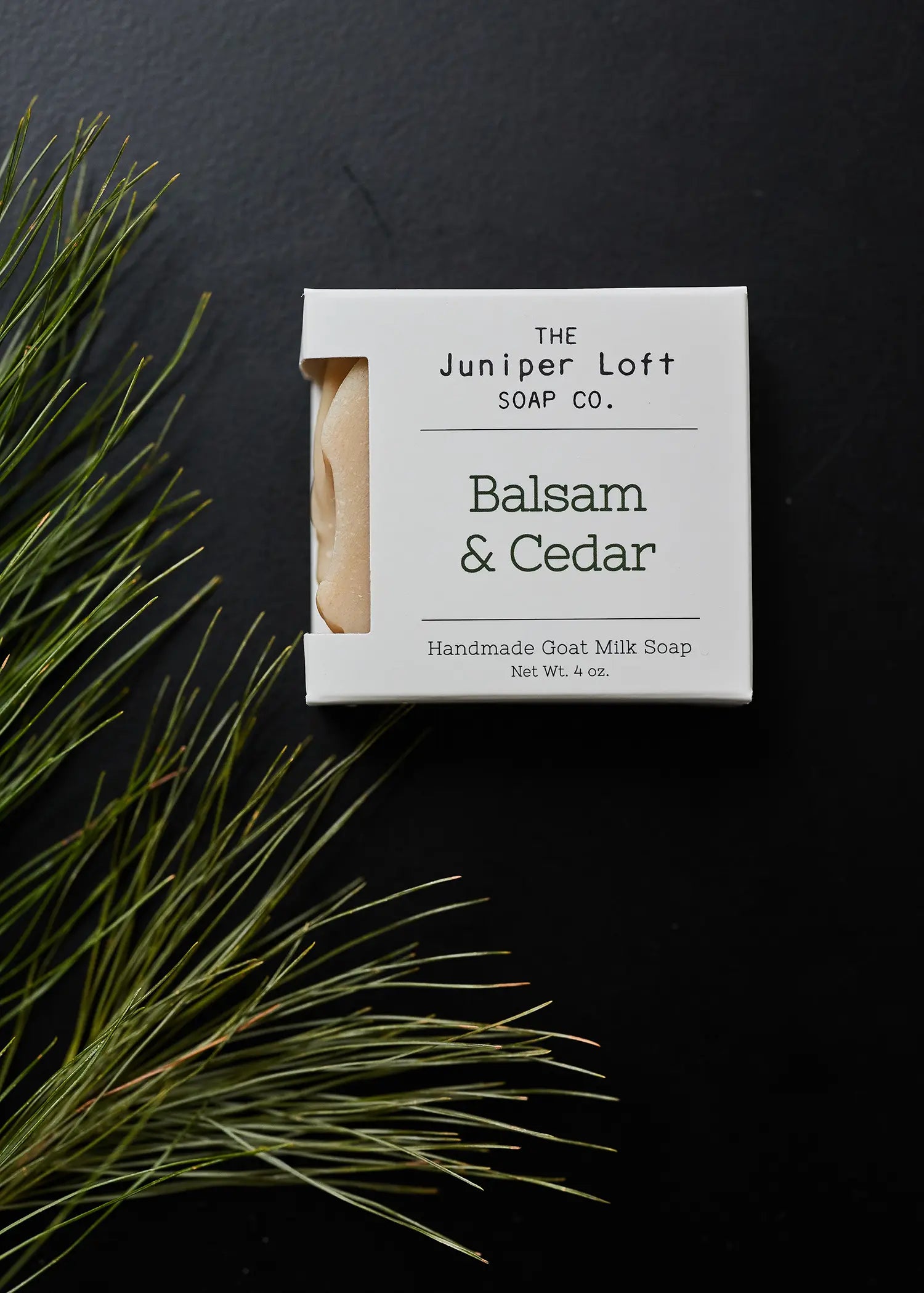 Box of Juniper Loft Balsam and Cedar soap on black slate and a cedar branch